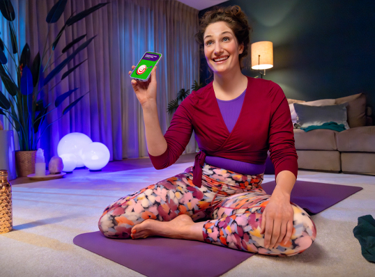 Yoga dame met Energiedirect op haar telefoon
