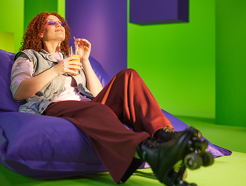 Vrouw met zonnebril, sapje en rolschaatsen geniet van de zon