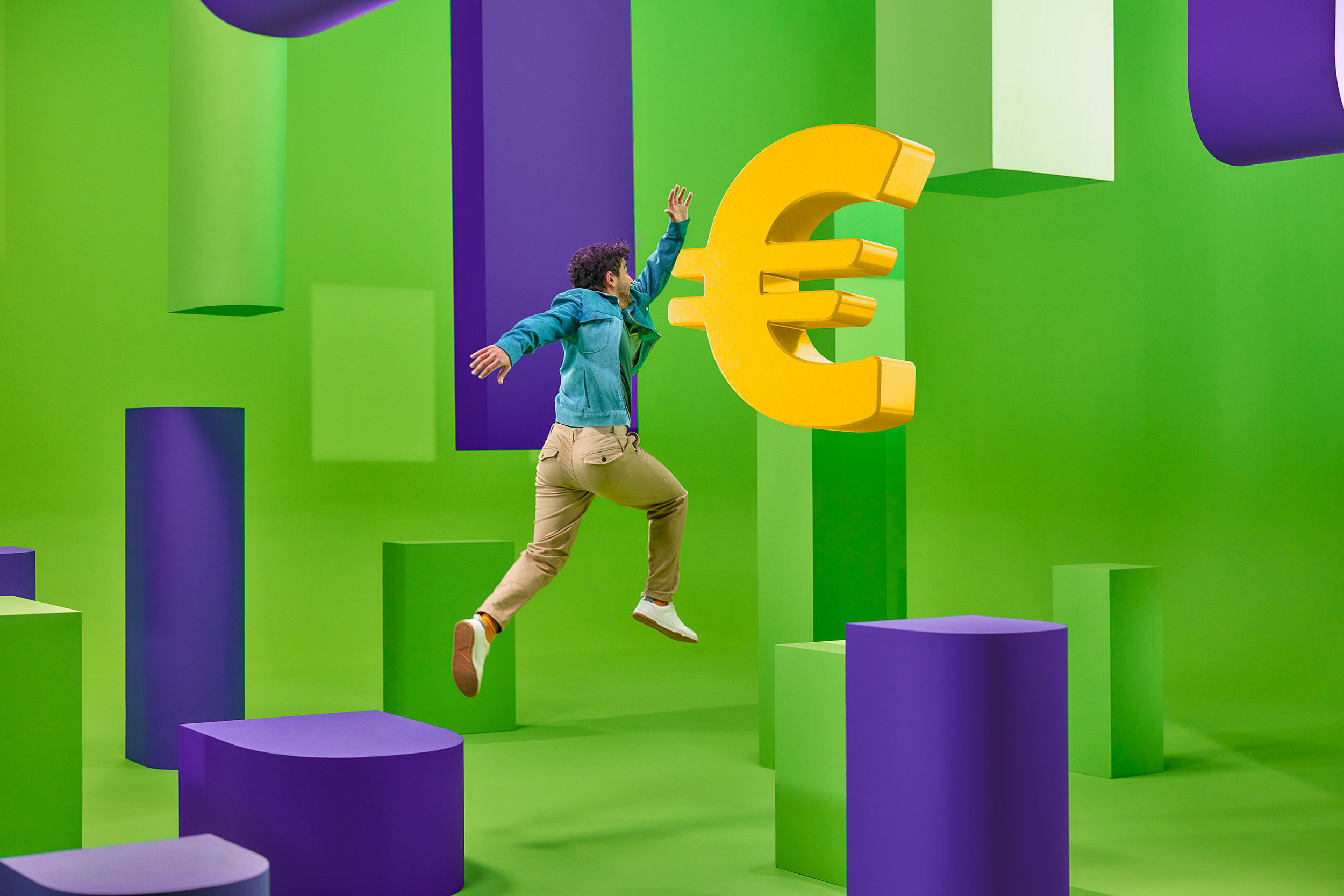 Een man springt naar een zwevend euroteken